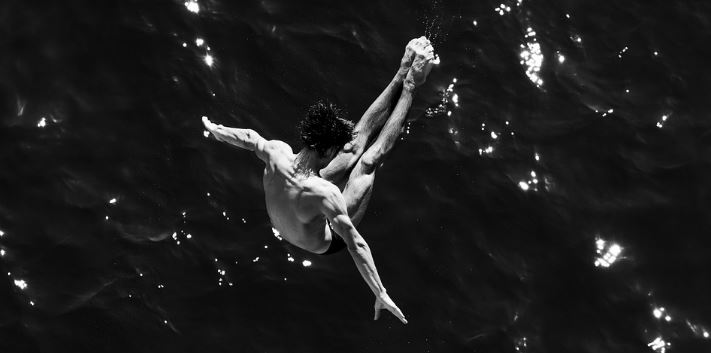 Mann springt ins Wasser