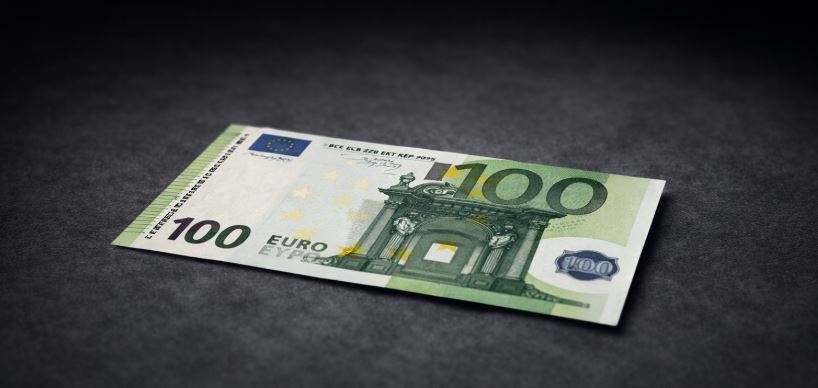 100-Euro-Schein auf einem dunklen Schreibtisch als symbolisches Bild für Geldanlage und Vermögensaufbau